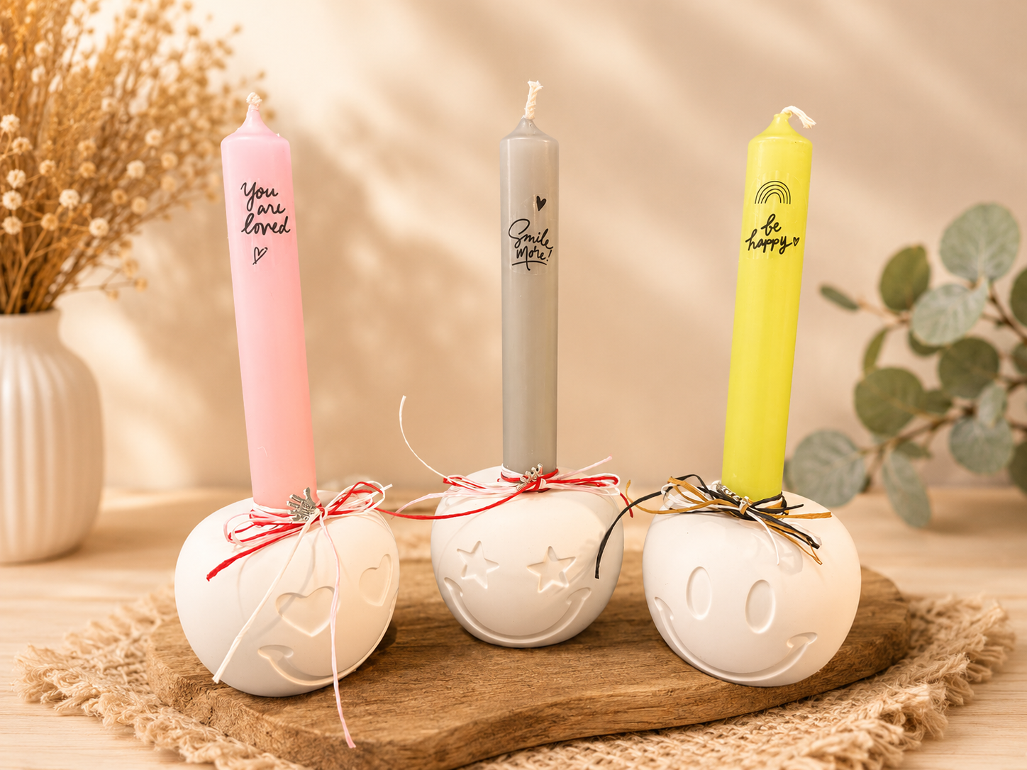 Drei Smiley-Kerzenhalter aus Keramik mit personalisierten Stabkerzen